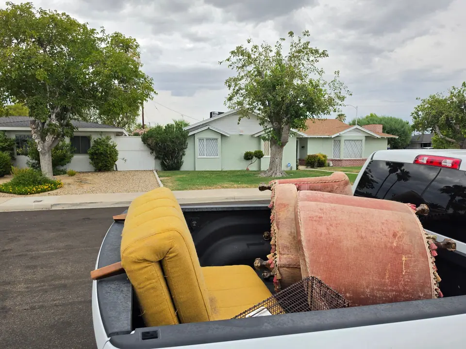 Yellow armchair and two pink upholstered chairs in a pickup bed outside a Las Vegas home